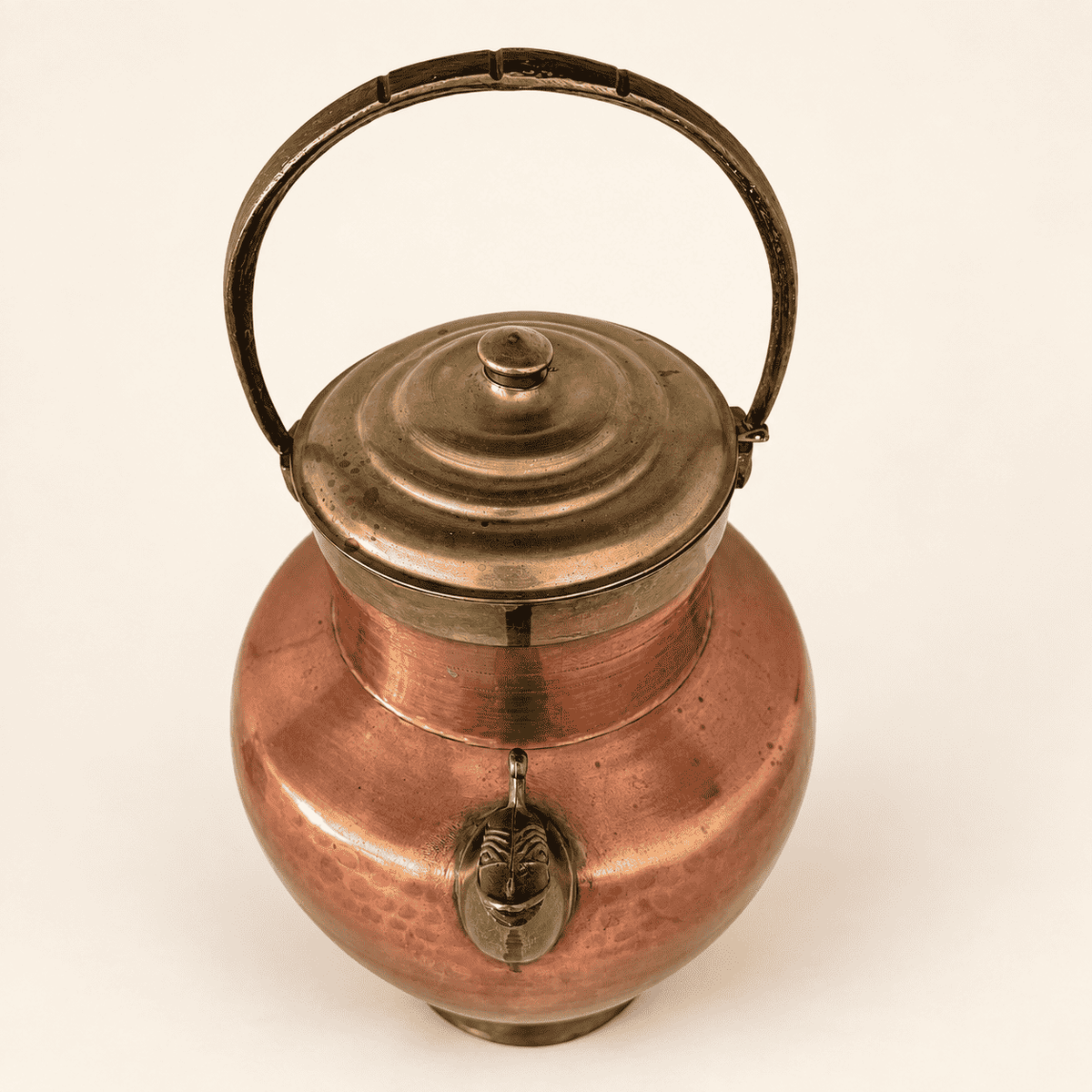Brass domed lid, finial, and arched handle of the copper ewer