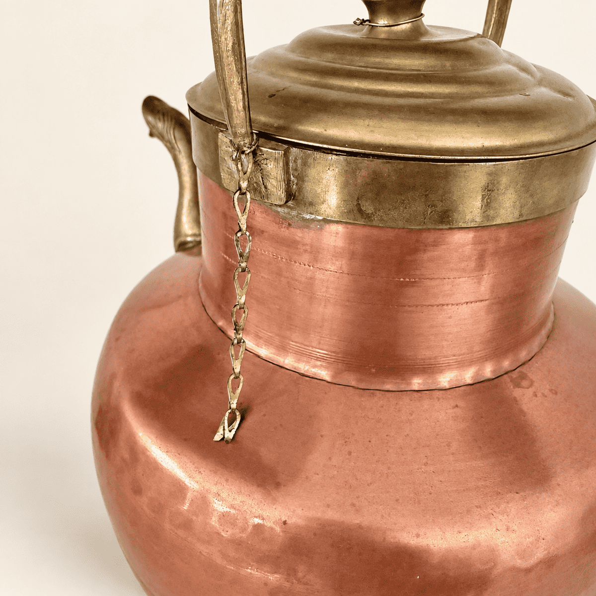 Underside of the brass lid and the small tether chain