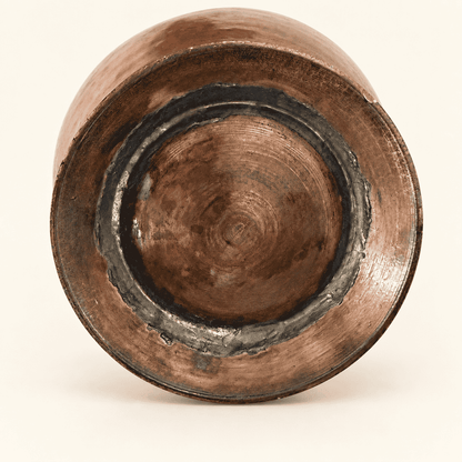 Bird-head brass spout against the hammered copper body of the ewer