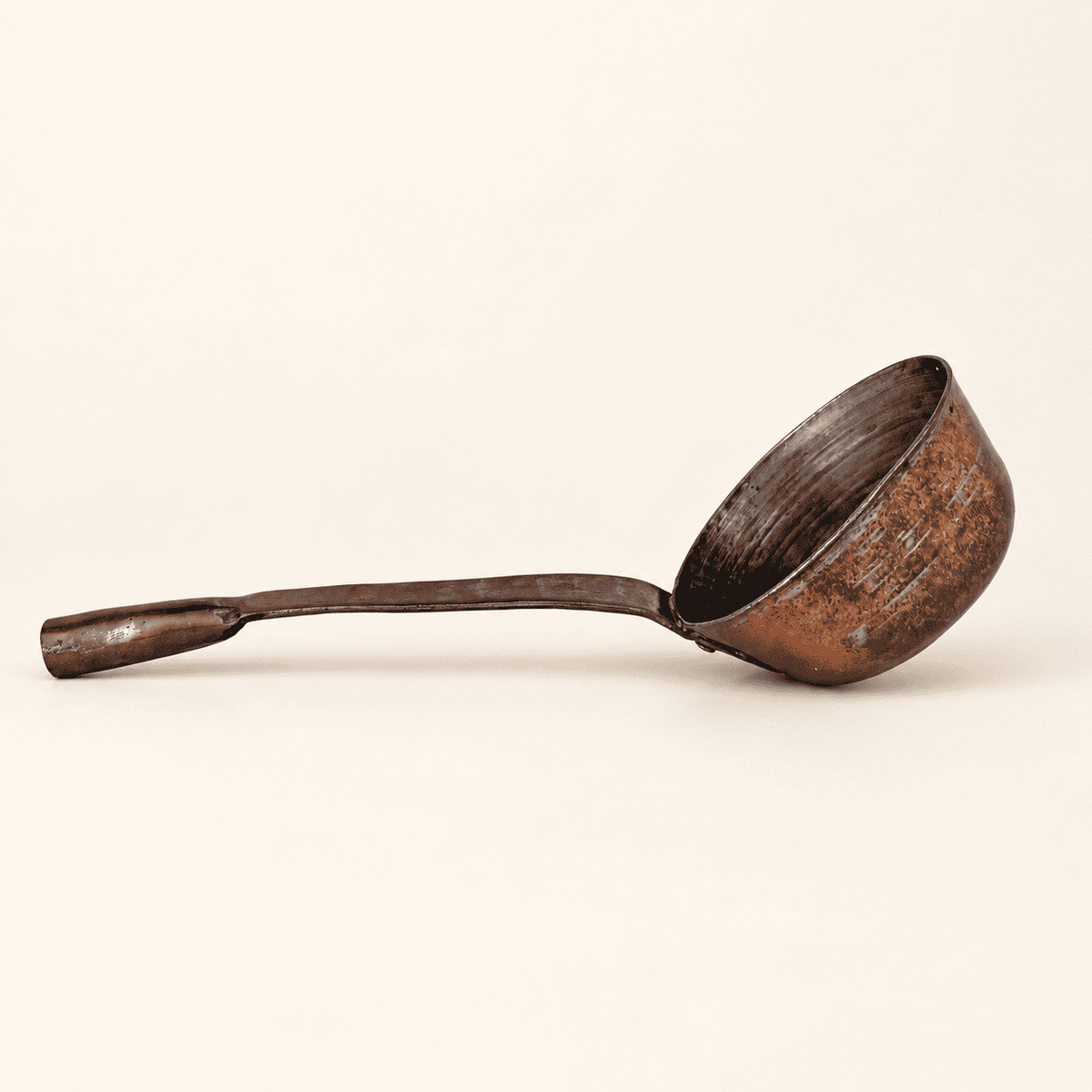 Antique hand-forged copper dipper in profile, long handle and deep tin-lined bowl