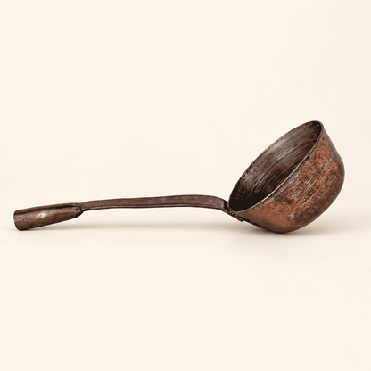 Antique hand-forged copper dipper in profile, long handle and deep tin-lined bowl