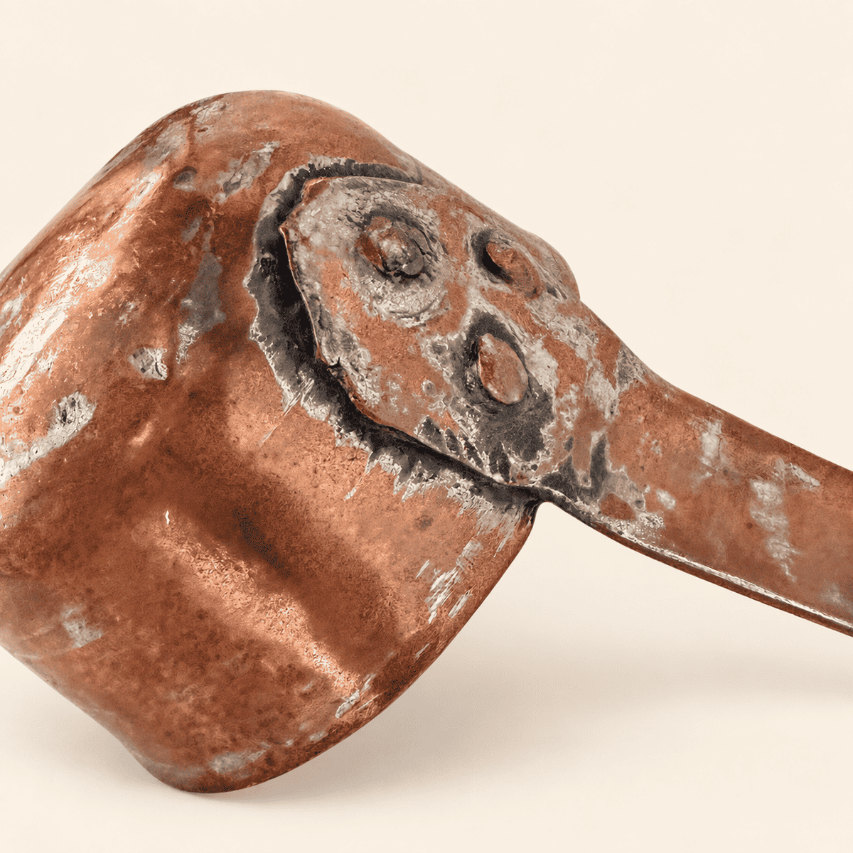 Close detail of the riveted handle-to-bowl joint with copper rivets and old solder