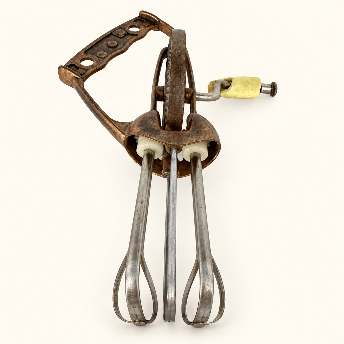 The egg beater upright, copper handle and gear above the stainless beaters