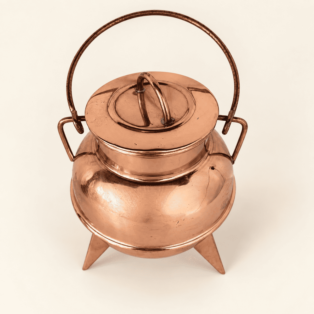 Copper cauldron with the swing bail raised over the lid