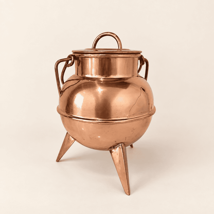 Copper footed cauldron with lid and swing handle, front view on three spike feet