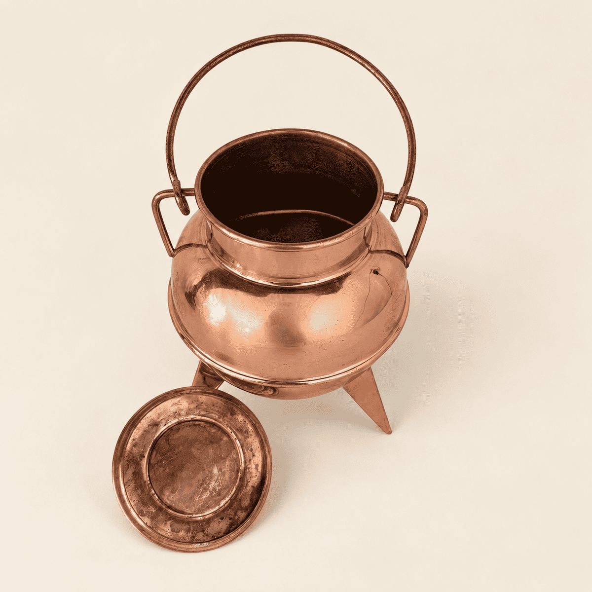 Copper cauldron open with the lid off to the side, showing the interior