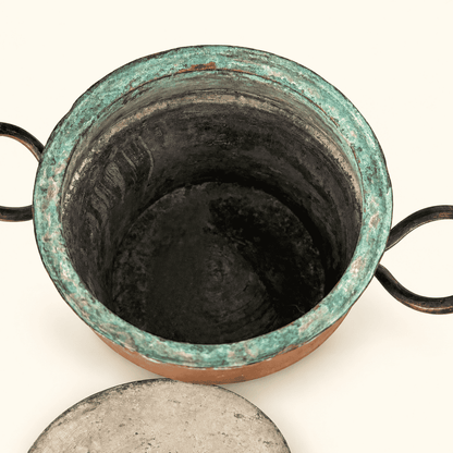 Copper pot with the lid off, looking down into the patinated interior, lid set in front