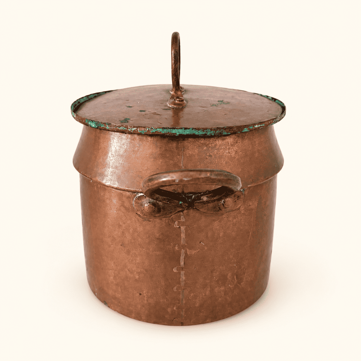 Riveted loop handle and the vertical dovetailed seam running down the copper body