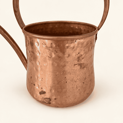 Hammered copper body and arched handle of the watering can