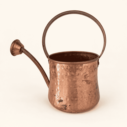 Hammered copper watering can with brass handle and rose spout, front view