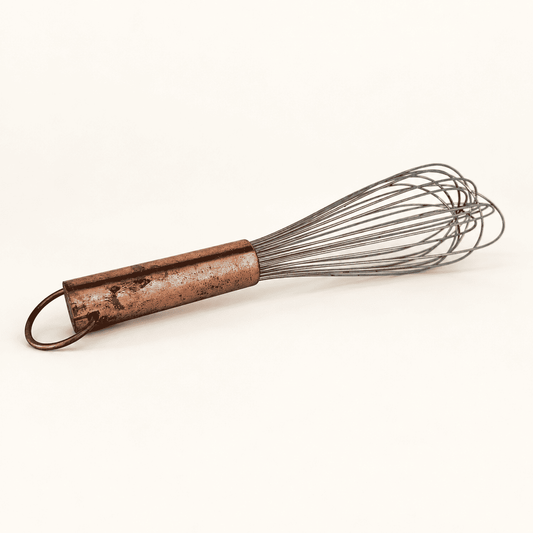 Vintage balloon whisk with a copper handle and brass hanging ring, full view