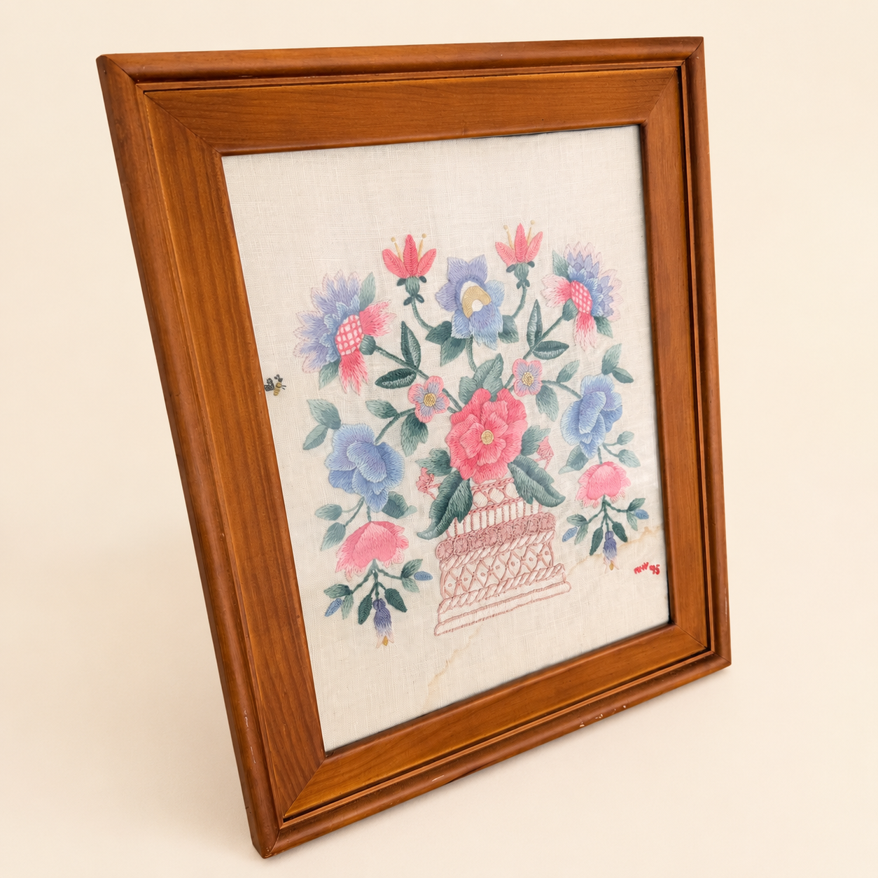 Angled view of framed crewel embroidery