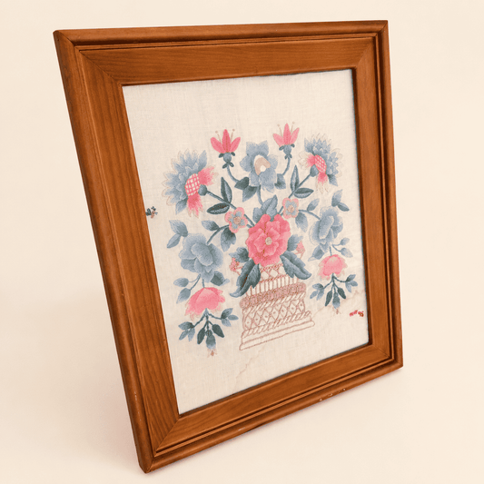 Angled view of framed crewel embroidery