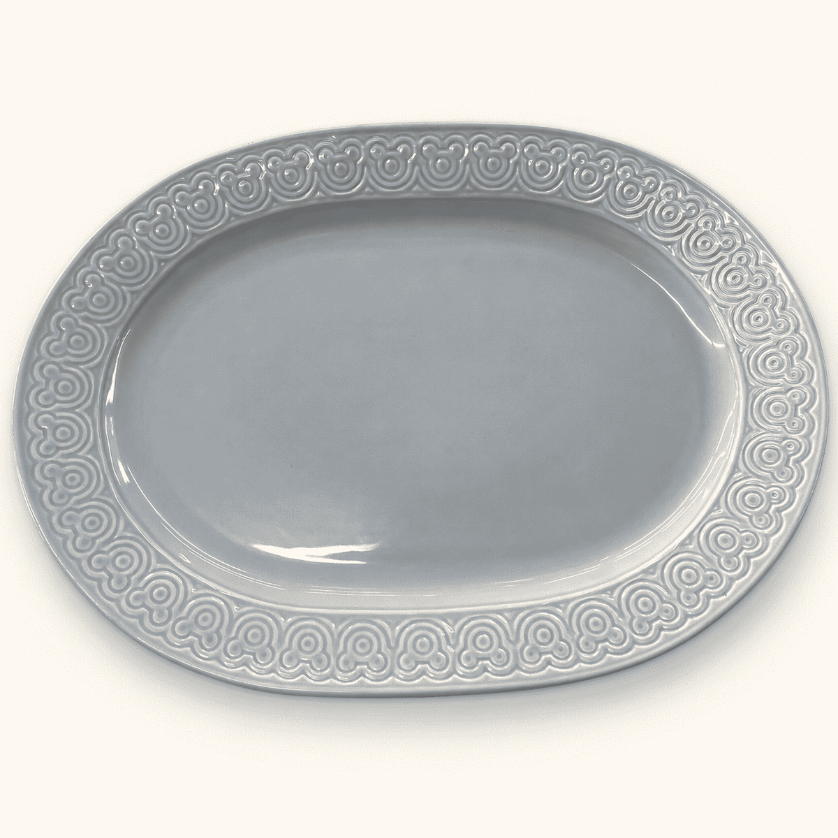 Disney stoneware platter in blue gray with an embossed Mickey ears rim, at an angle