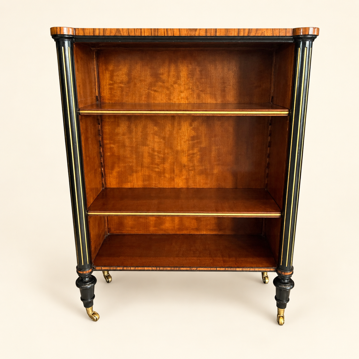 Antique Edwardian rosewood open bookcase with ebonized gilt columns and brass casters, front view