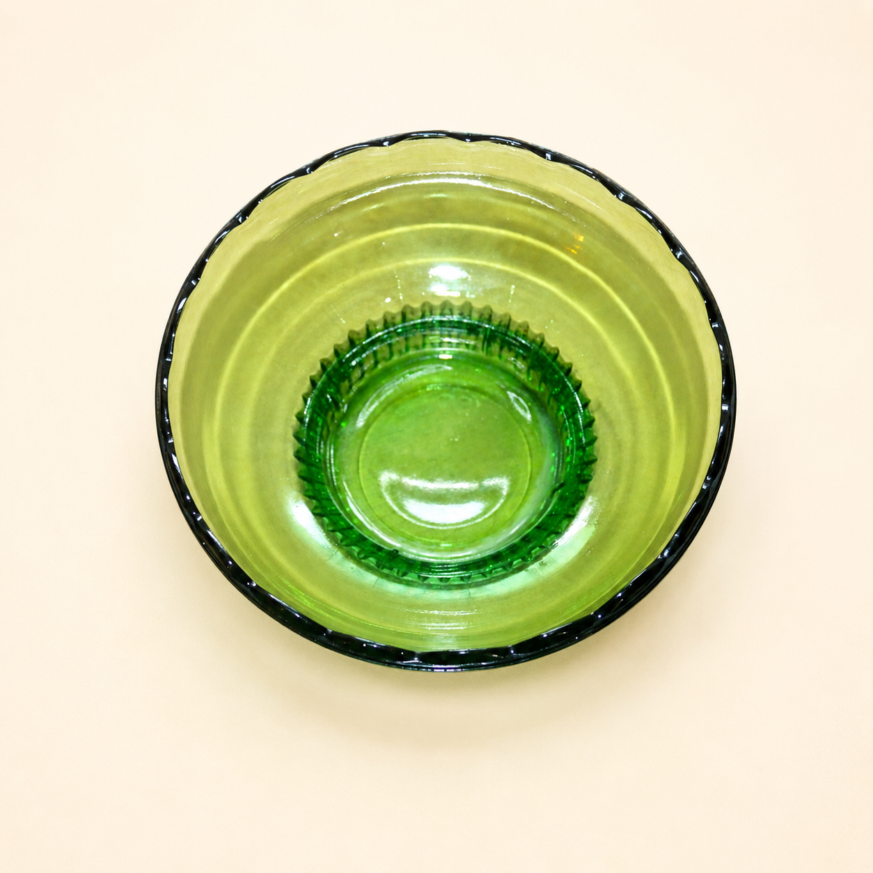 Top-down view into green glass bowl showing reeded foot interior
