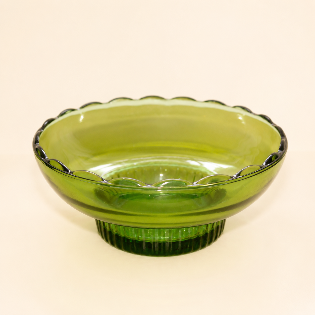 Angled view of vintage E.O. Brody emerald green footed bowl with teardrop lace rim