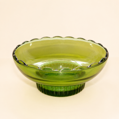 Angled view of vintage E.O. Brody emerald green footed bowl with teardrop lace rim