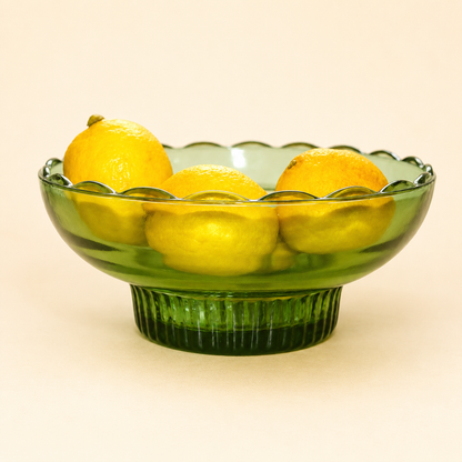 E.O. Brody green glass pedestal bowl with open lace rim, holding lemons