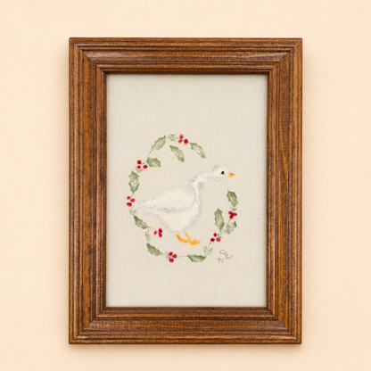 Framed goose embroidery with painted holly wreath, signed 1991