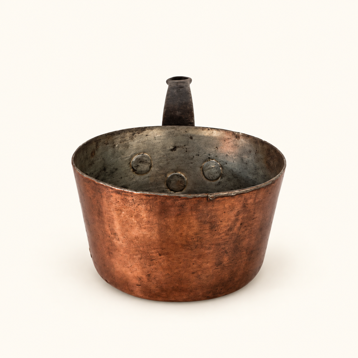 Looking into the tin-lined copper pan, copper rivet heads showing inside