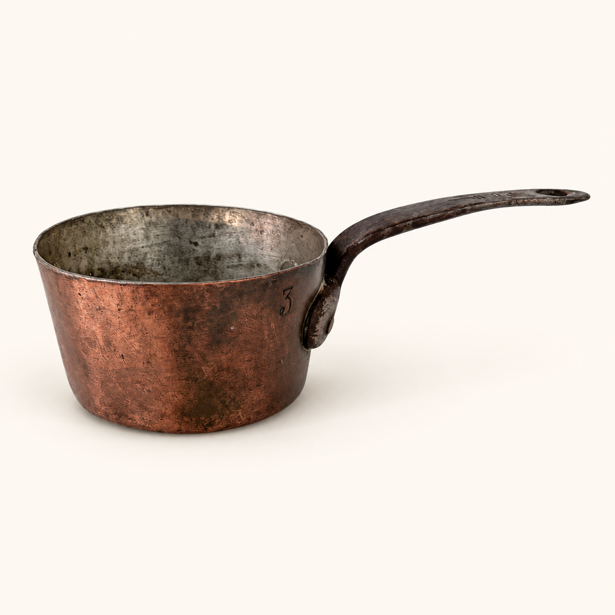 Copper saucepan in profile with a stamped size 3 and the forged iron handle