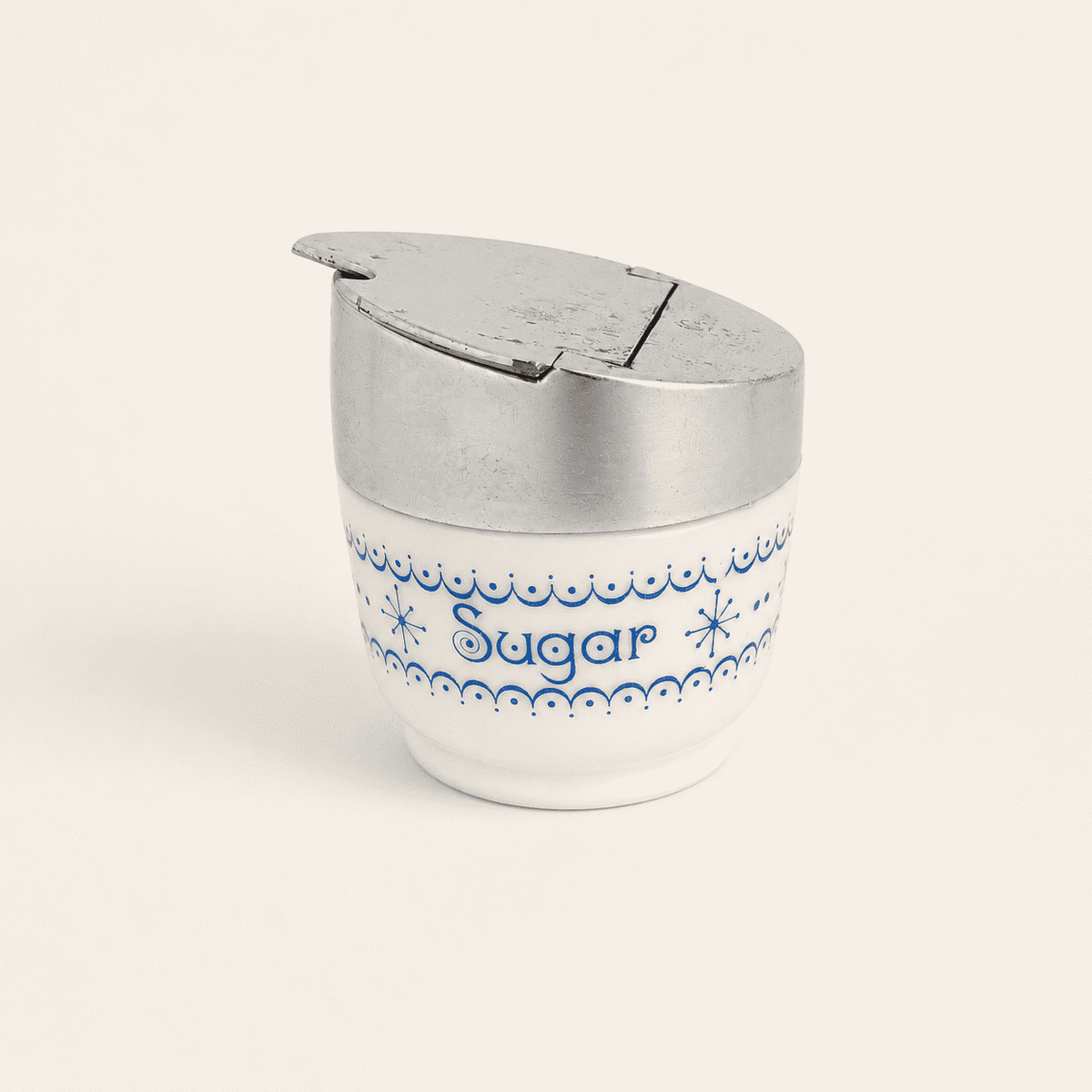 Gemco milk glass sugar dispenser with blue snowflake garland and flip lid, front view