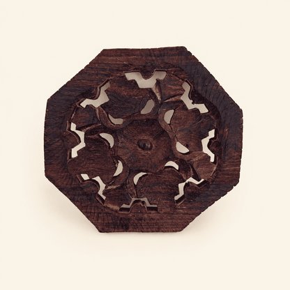 Hand-carved octagonal wood trivet with pierced floral openwork center, front view