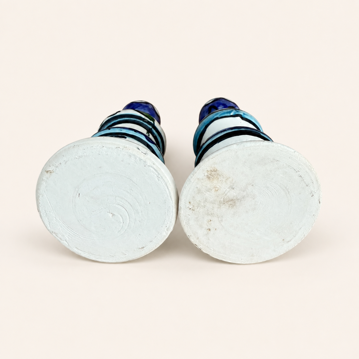 Unglazed white bases of the pair of hand-painted ceramic candlesticks