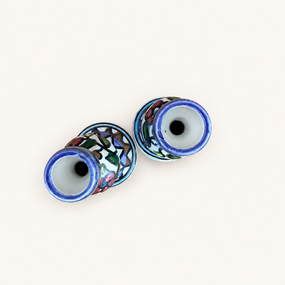 Top-down view of two candlestick openings showing blue-rimmed candle cups