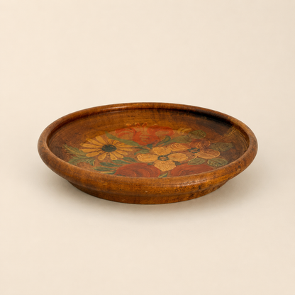 Side profile of turned wood folk plate showing raised rim and depth