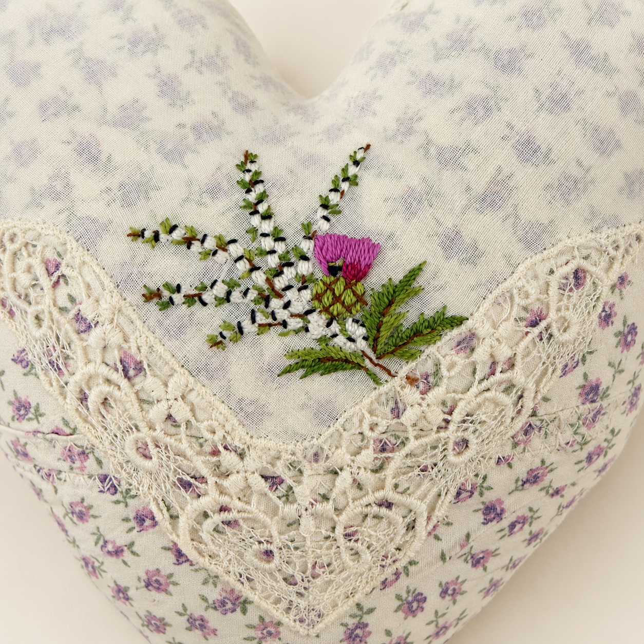 Detail of hand-embroidered Scottish thistle and heather on heart pillow