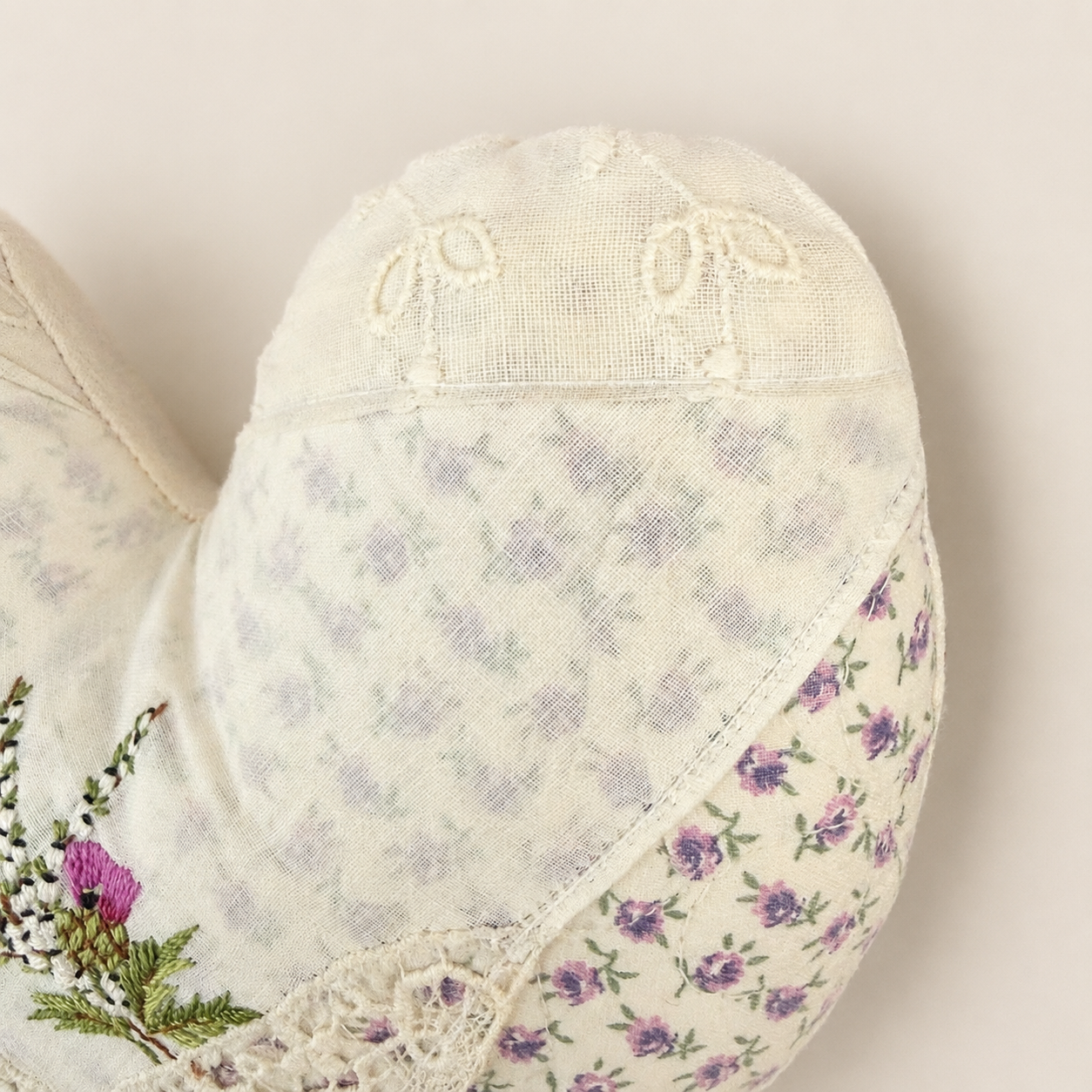 Close-up of antique lace corner on floral heart pillow
