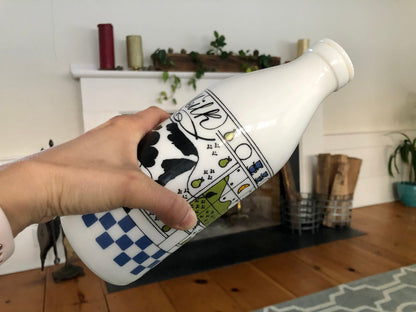 Hand holding the Alan Wood milk glass bottle on its side