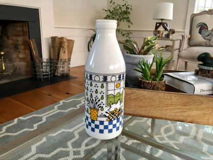 Side of the milk glass bottle with flowers in a yellow basket and a blue checkerboard border