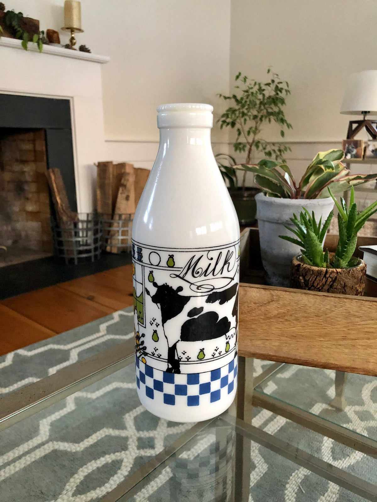 Alan Wood milk glass cow bottle standing on a glass coffee table