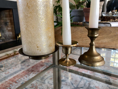 Trio of vintage solid brass candlesticks in graduated heights, styled with candles