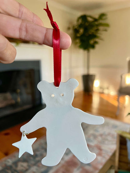 Handmade ceramic Christmas ornament of a bear in a green scarf holding a 2005 star, from Vermont — detail view