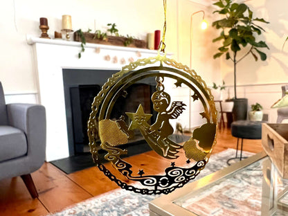 Etched brass Christmas ornament of an angel riding a shooting star, round relief design