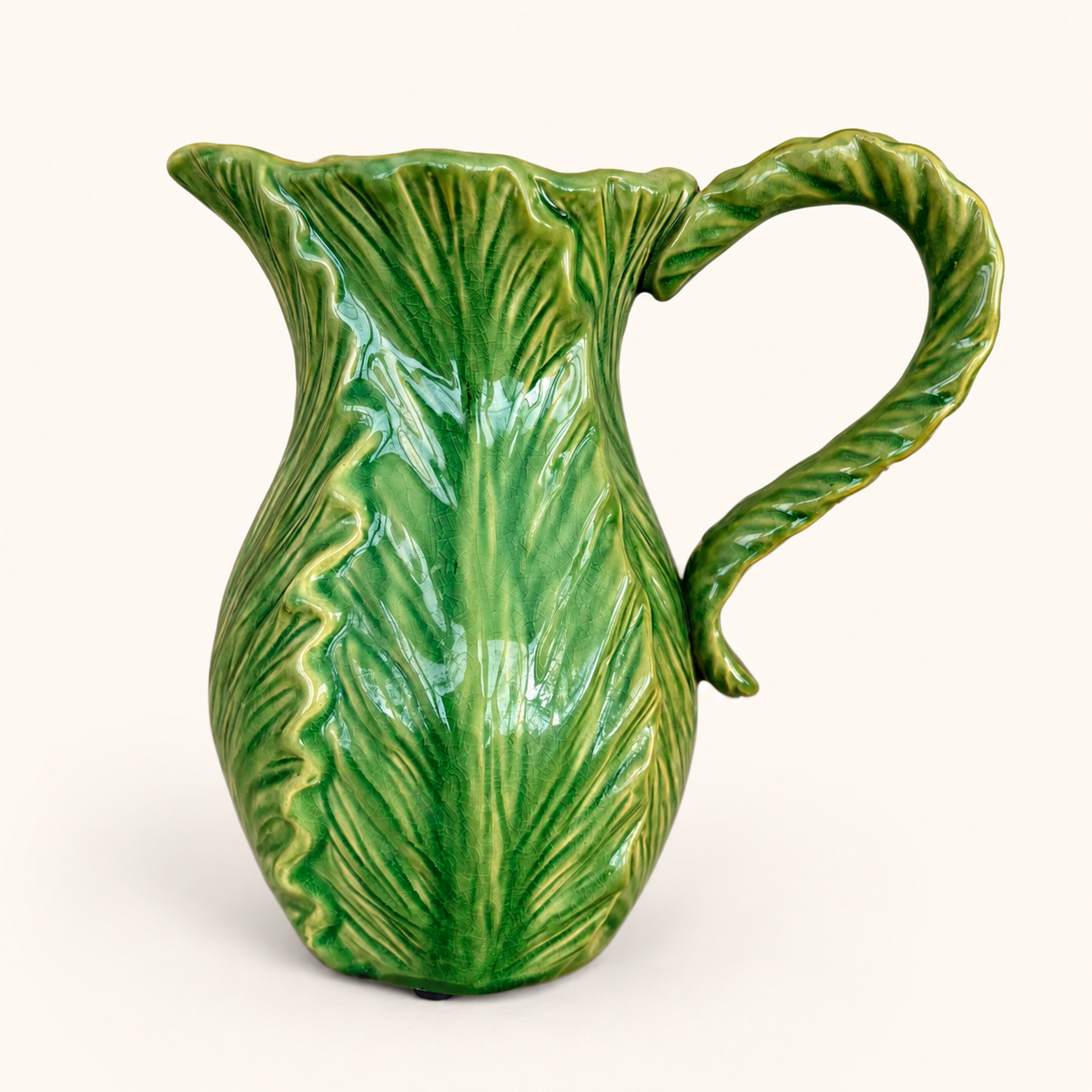 Side view of green cabbage leaf pitcher with leaf-form handle