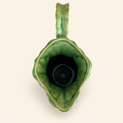 Top-down view into the pitcher spout showing glazed green interior