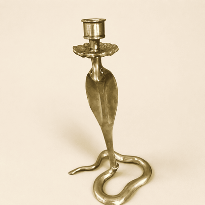 Angled view of brass cobra candlestick showing flared hood and candle cup
