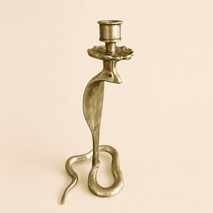 Three-quarter view of brass cobra candlestick with coiled serpent base