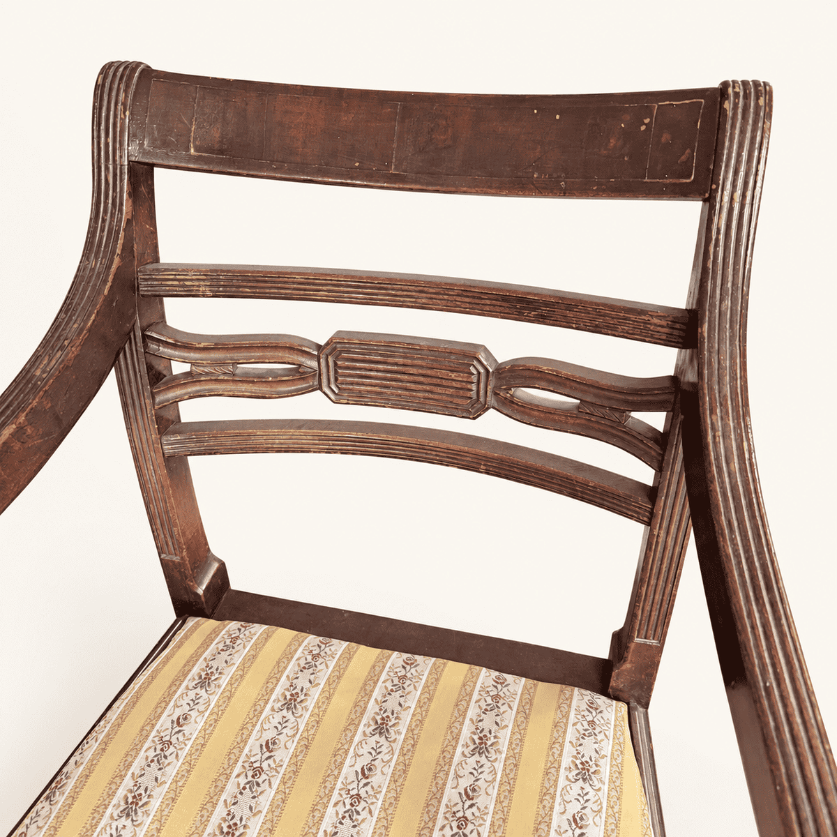 Reeded top rail and carved center splat of the bar back, worn finish