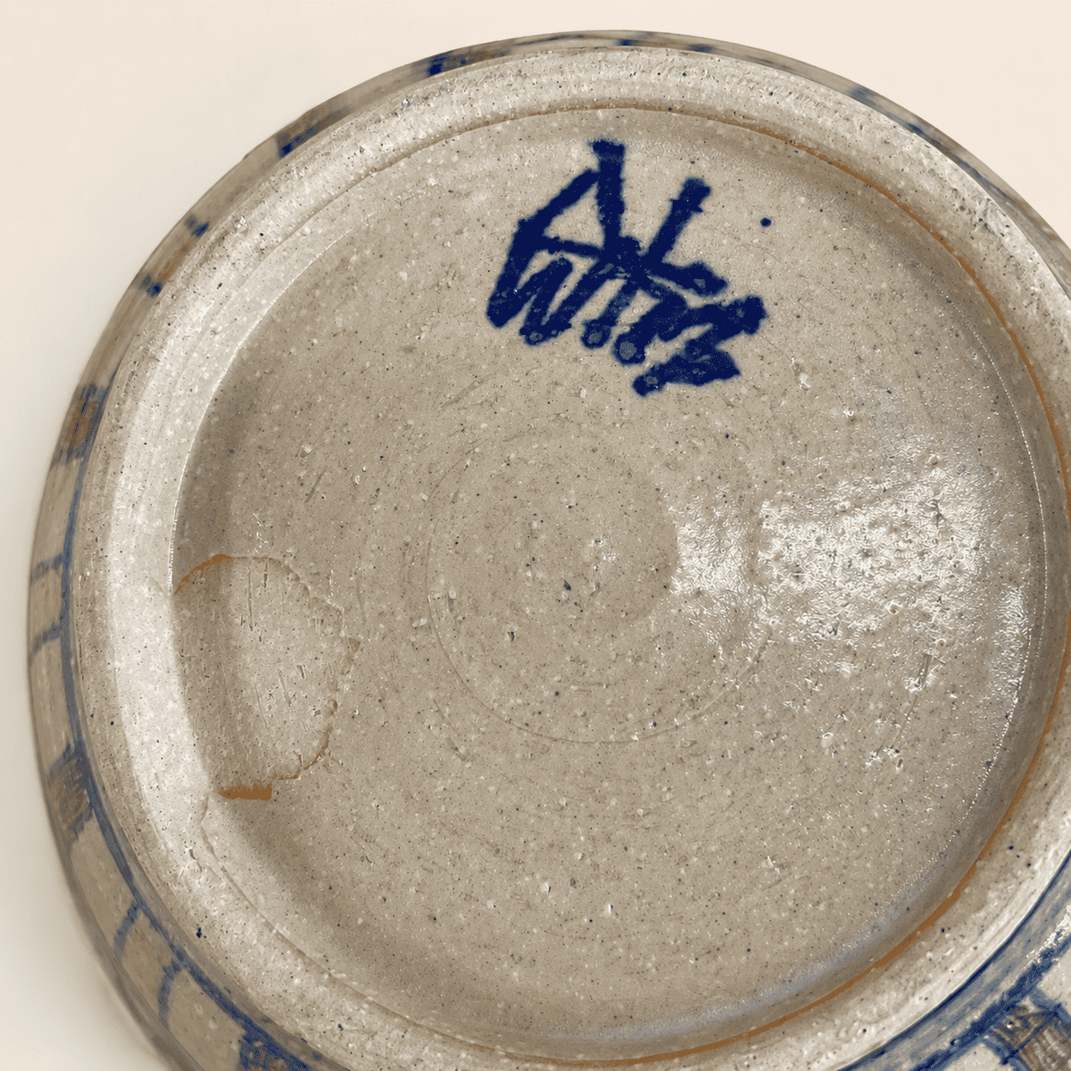 Base of studio pottery bowl showing blue painted artist's signature