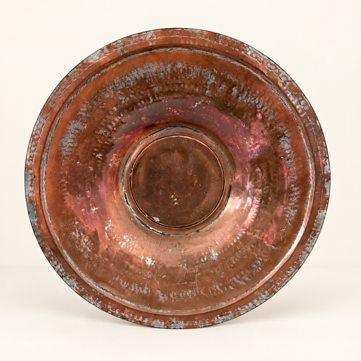 Tinned copper charger straight on, concentric hammered rings around the raised center