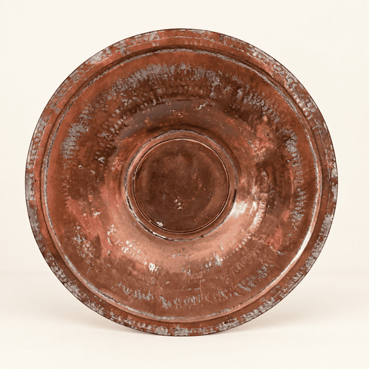 Tinned copper charger straight on, concentric hammered rings around the raised center