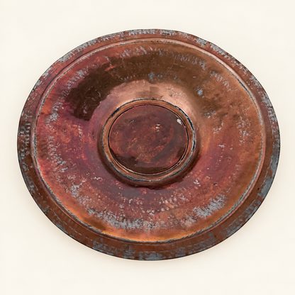 Face of the tinned copper charger, hammered well with a raised center medallion and scalloped rim