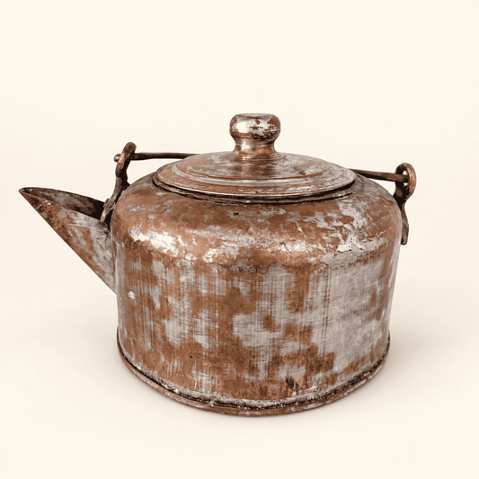 Antique hand-forged tinned copper kettle with a domed lid and brass swing bail, front view with short spout