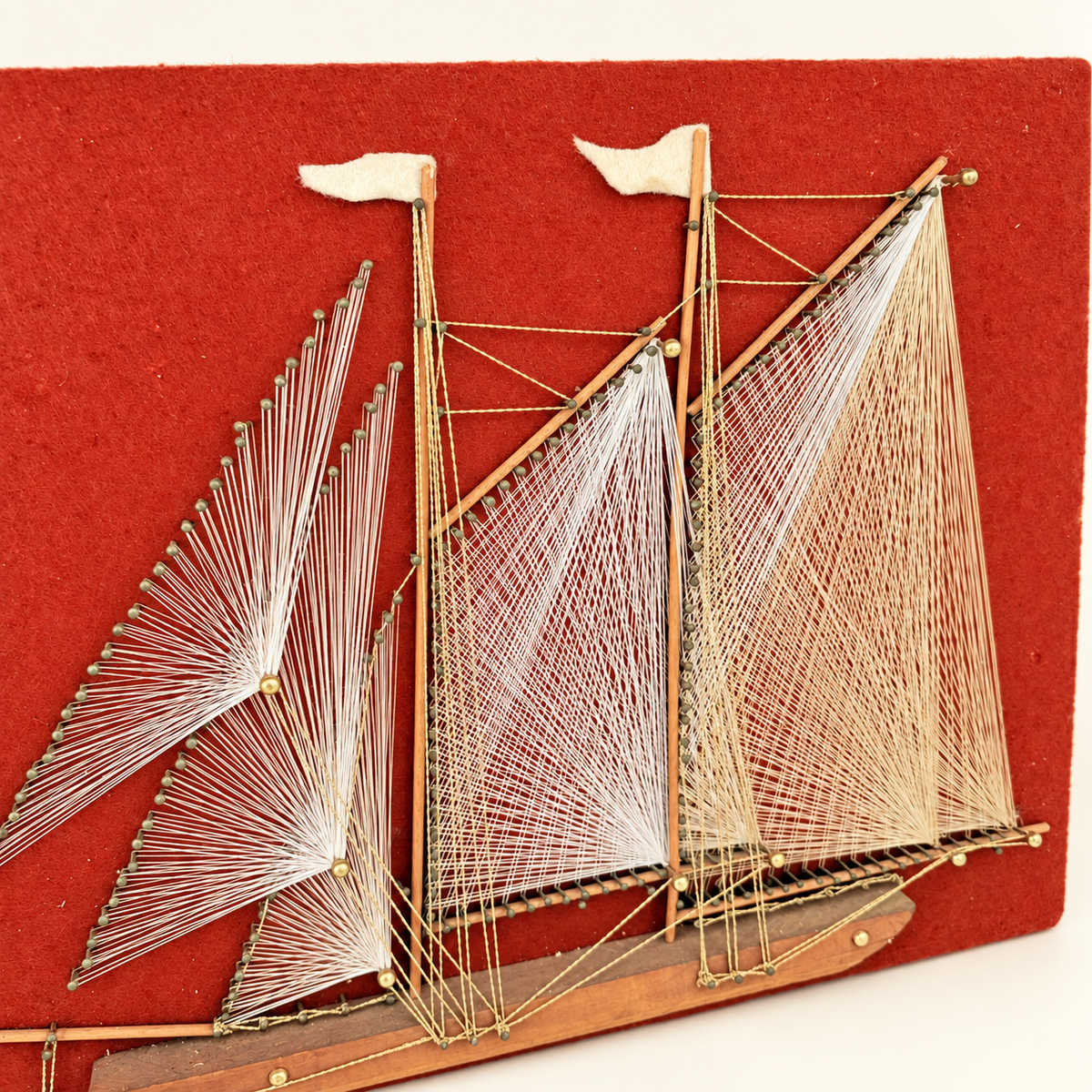 Angled view of string art sailboat with white and gold thread sails, photo 2 of 5
